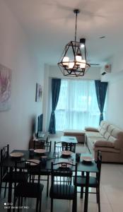 a living room with a table and chairs and a couch at Leisure homestay@Sutera Avenue 2-0519 in Kota Kinabalu
