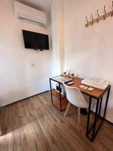 a room with a table and a chair and a television at Hostel Sweet Home Palermo Soho in Buenos Aires