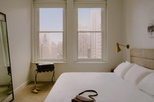 een slaapkamer met een wit bed en 2 ramen bij Sonder The Witherspoon in Philadelphia
