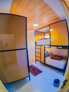 a small room with two bunk beds and a door at Atlantic Vibes Surf Hostel in Tamraght Ouzdar