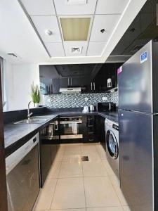 een keuken met een roestvrijstalen koelkast en een vaatwasser bij Luxury Botanica Apartment 268 in Dubai