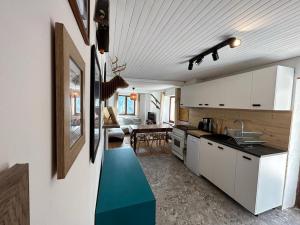 a kitchen with white cabinets and a blue floor at Le Crampon in Les Orres