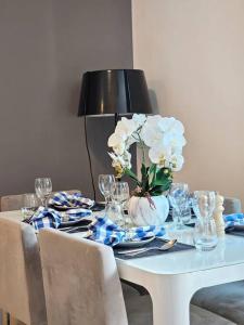 een witte tafel met een vaas met bloemen erop bij Luxury Botanica Apartment 268 in Dubai