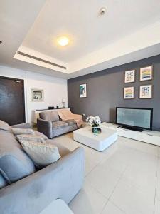 een woonkamer met een bank en een tv bij Luxury Botanica Apartment 268 in Dubai