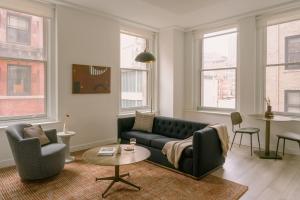 a living room with a couch and chairs and windows at Sonder The Witherspoon in Philadelphia