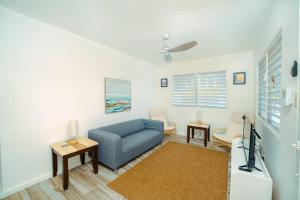 sala de estar con sofá azul y TV en Panoramic Escape with Private Pool, en Mayagüez