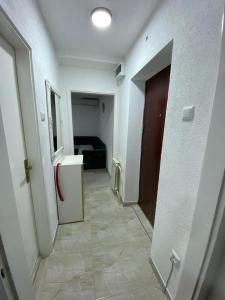 a hallway of a room with a door and a refrigerator at Stan na dan Hasanovic in Tuzla