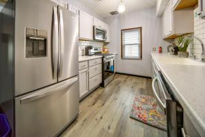 uma cozinha com um frigorífico em aço inoxidável e pisos em madeira em Cozy Erie Vacation Rental with Patio and Seasonal Pool em Erie