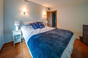 a bedroom with a bed with a blue blanket on it at Cozy Erie Vacation Rental with Patio and Seasonal Pool in Erie
