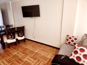 a living room with a couch and a tv on a wall at Hostel Pepe Lima in Lima