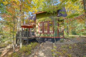 une maison verte avec une terrasse dans les bois dans l'établissement Enchanting Retreat with Private Deck and River Access!, à Hot Springs