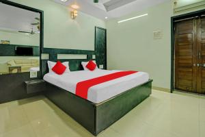 a bedroom with a large bed with red pillows at Flagship Hotel Pragya 4 in Raipur