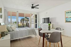 a bedroom with a bed and a table and chairs at Beacfront Petite Paradise unit at Pelican Reef 103 in Rincon