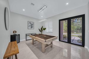 Habitación con mesa de ping pong y banco en Luxury Villa Amara w/Heated Pool/Sauna/Gym/BBQ en Miami