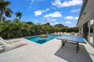 einen Pool mit einer Tischtennisplatte im Hinterhof in der Unterkunft Luxury Villa Amara w/Heated Pool/Sauna/Gym/BBQ in Miami