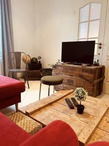 sala de estar con TV de pantalla plana sobre una mesa de madera en LA MARIEFACTURE- Comme à l'Armée, 
