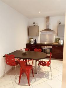 a kitchen with a table and chairs and a stove at LA MARIEFACTURE- Comme à l'Armée 