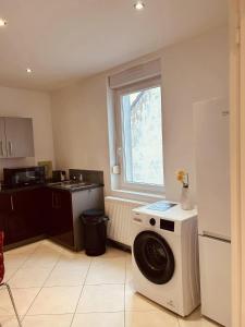 a kitchen with a washing machine and a window at LA MARIEFACTURE- Comme à l'Armée 