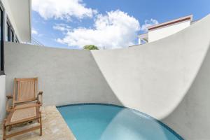 una silla junto a una pared con piscina en Casa Loba Luxe Unit 3 with private pool en Rincon