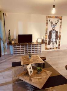 ein Wohnzimmer mit 2 Tischen und einem Bild eines Hirsches in der Unterkunft LA MARIEFACTURE - Comme c'est tout bêtes ! in Faulquemont