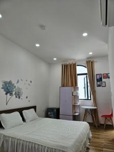 a bedroom with a large bed and a red chair at Homestay ánh chi in Phú Quốc