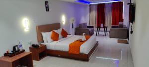 a bedroom with a bed and a living room at Grand Signature Hotel & spa in Yercaud