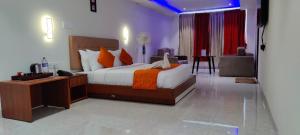 a hotel room with a bed and a desk and a room at Grand Signature Hotel & spa in Yercaud
