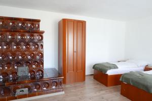 a bedroom with two beds and a wooden cabinet at Szabó Porta Vendégház in Zalaháshágy
