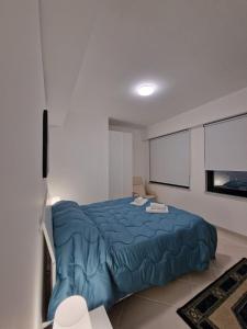 a bedroom with a blue bed and a window at Fabien's House in Palermo