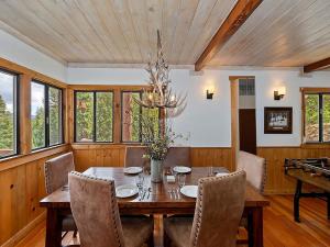 comedor con mesa, sillas y lámpara de araña en 136 - Historic Rustic Cabin en Big Bear Lake