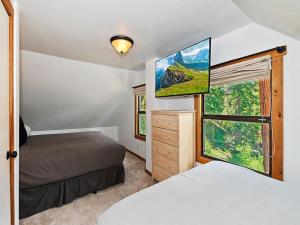 1 dormitorio con 2 camas y ventana en 136 - Historic Rustic Cabin en Big Bear Lake