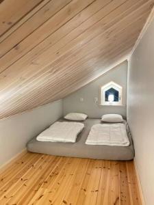 two beds in a room with a wooden floor at Penthouse close to Vasaloppet finish line portal in Mora