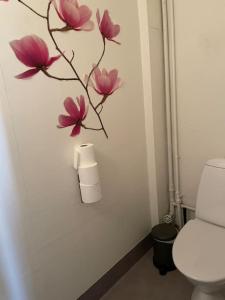 a bathroom with a toilet with pink flowers on the wall at Skraddaren, close to Vasaloppet finish line portal in Mora