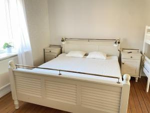 1 dormitorio con 1 cama blanca grande y 2 almohadas en Brewer by MoraTomten, en Mora