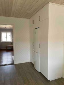 ein leeres Zimmer mit einem weißen Kühlschrank darin in der Unterkunft Brewer by MoraTomten in Mora