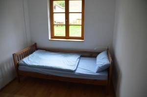 - un petit lit dans une chambre avec fenêtre dans l'établissement Ferienwohnung Uckermarkblick, à Ziehten