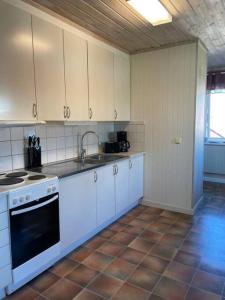 a kitchen with white cabinets and a stove top oven at Skomakaren, near Vasalopp finish line portal in Mora in Mora