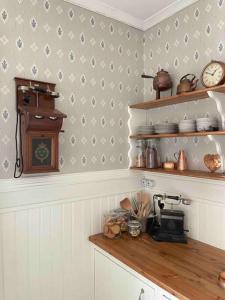 a kitchen with a counter with a clock on the wall at MoraTelegrafen in central Mora in Mora