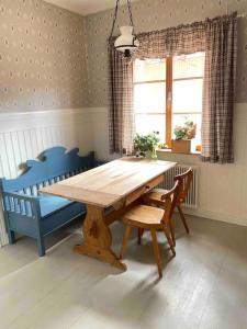 una mesa de madera en una habitación con 2 sillas azules en MoraTelegrafen in central Mora, en Mora