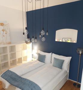 Bett in einem Zimmer mit blauer Wand in der Unterkunft Vienna Charm Apartment in Wien