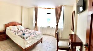 a bedroom with a bed and a window at HOTEL CARIAMANGA in Santo Domingo de los Colorados