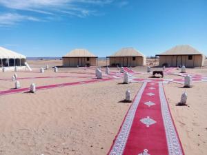 un tapis rouge au milieu du désert dans l'établissement SAHARA WAVES CAMP, à Merzouga