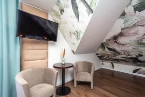 a living room with a tv and two chairs and a table at Hotel i Restauracja Stara Kuźnia in Dobczyce