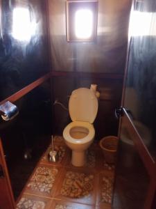a small bathroom with a toilet with a window at SAHARA WAVES CAMP in Merzouga