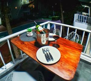 uma mesa de madeira com uma garrafa de vinho e copos em Sol Caribe Beach Group em Punta Cana