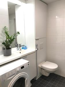 uma casa de banho com uma máquina de lavar roupa e um WC em Modern Studio, free parking & wifi, Aino Areena 300m em Järvenpää