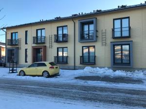 a yellow car parked in front of a building at Modern Studio, free parking & wifi, Aino Areena 300m in Järvenpää