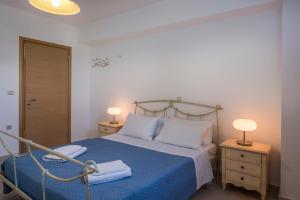 a bedroom with a bed with a blue blanket and two lamps at Villa Katerina in Chania Town