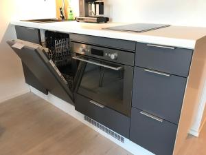 uma cozinha com um balcão e uma máquina de lavar louça em Modern Studio, free parking & wifi, Aino Areena 300m em Järvenpää