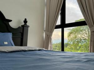 ein Schlafzimmer mit einem Bett und einem großen Fenster in der Unterkunft Ipoh Simple Homestay by Comfort Home in Ipoh + 41 Fotos